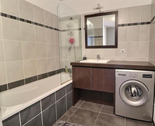 a bathroom with a sink and a washing machine at Appartement Cosy in Le Crès