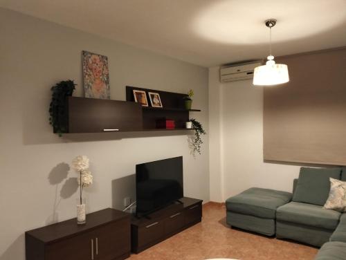 a living room with a couch and a flat screen tv at La estrella del desierto in Tabernas