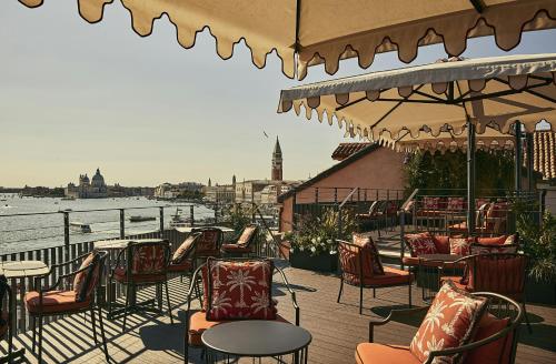 a patio with chairs and tables and a view of the water at Hotel Gabrielli Venezia - Starhotels Collezione in Venice