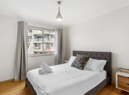 a bedroom with a bed and a window at 2-Bed Unit with Balcony BBQ & Stunning Lake Views in Belconnen