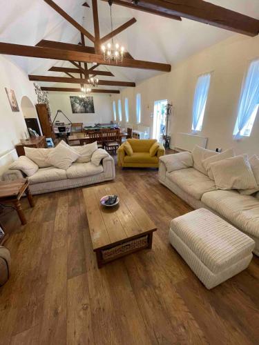 a living room with two couches and a coffee table at The Old Hay Barn - Games Room, Gym, Sleeps 8 in Godmanchester
