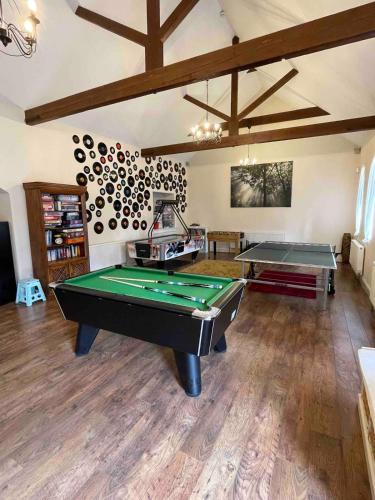 a room with a pool table and ping pong balls at The Old Hay Barn - Games Room, Gym, Sleeps 8 in Godmanchester