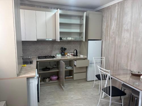 ギュムリにあるHyuratunのキッチン(白いキャビネット、カウンター、椅子付)