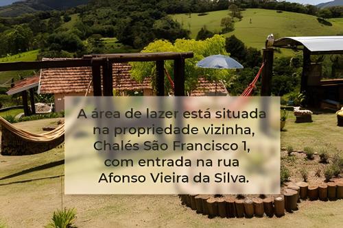a sign in front of a garden with a mountain at Chalés São Francisco I in Santo Antônio do Pinhal