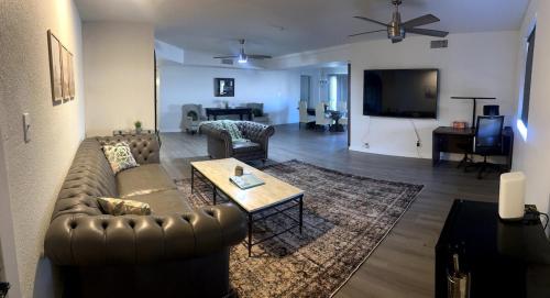 ein Wohnzimmer mit Sofa und Tisch in der Unterkunft Mins to Mayo Clinic Modern Retreat Desert Ridge in Phoenix