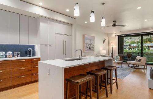 ジャクソンにあるSlopeside 2BR Retreat at Snow King Walk to Townのキッチン(シンク、バースツール付)