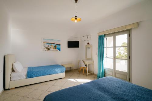 a bedroom with two beds and a window at my life suites in Fira