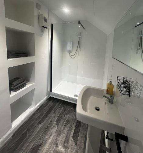 a white bathroom with a shower and a sink at Perth City Centre Apartment - Short & Long Stays Welcome - 2x Smart TVs - Sky TV - Fast WiFi - Fully Equipped - Located Next to All Amenities in Perth