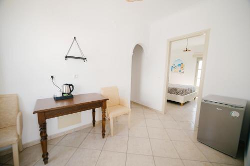 a living room with a desk and a bedroom at my life suites in Fira