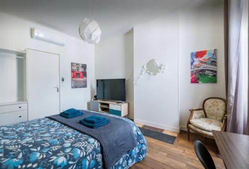 een slaapkamer met een bed, een tv en een tafel bij Apart city in Montargis