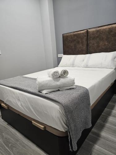a bed with two towels sitting on top of it at Tanez Garden Apartamentos in Madrid