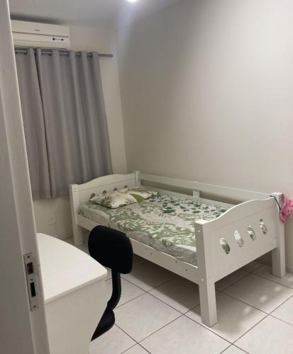 a small bedroom with a bed and a desk at Casa 183 in Itajaí