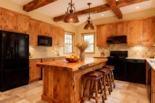 a kitchen with wooden cabinets and a large island with bar stools at Jackson Hole Alpine Residence in Jackson