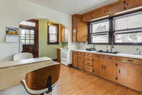 a large kitchen with wooden cabinets and a sink at 1 Mi to Downtown Dubuque! Spacious Home in Dubuque