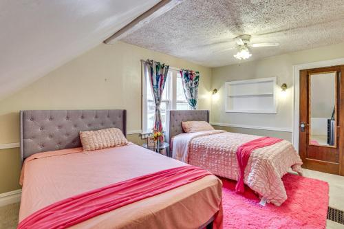 a bedroom with two beds and a pink rug at 1 Mi to Downtown Dubuque! Spacious Home in Dubuque