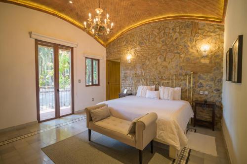 a bedroom with a large bed and a chair at Villa Toscana ValQuirico Lofts & Suites Hotel Boutique in Santeagueda