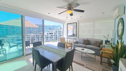 a living room with a ceiling fan and a table with chairs at Departamento Mike's in Nuevo Vallarta 