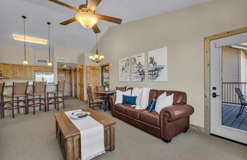 een woonkamer met een bank en een tafel bij Penthouse Retreat Steps from the Gondola in Park West Ski Area Heliport