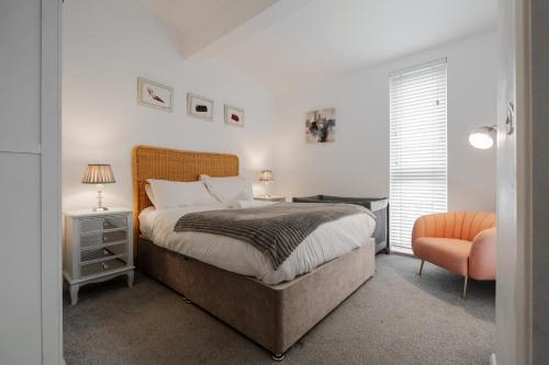 a bedroom with a large bed and a chair at City Stay Haven - Coop Live - Etihad - Sleeps 9 - Free Parking in Manchester