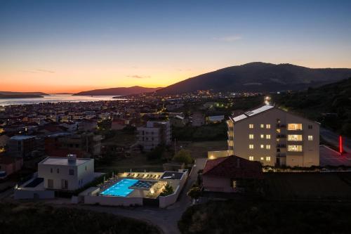 een gebouw met een zwembad voor een stad bij Apartments Top Hill in Trogir