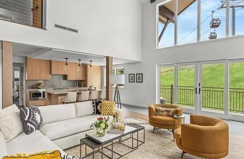 a living room with a couch and chairs and a kitchen at Ski-In Ski-Out Escape with Mountain Views in Snowm in Snowmass Village