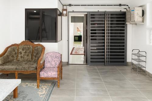 Simpang EmpatにあるWelcome to MANAF HOME STAY, 3 Fully Furnished bedrooms, located in beautiful Alor Gajah, Melakaのリビングルーム(椅子、窓付)