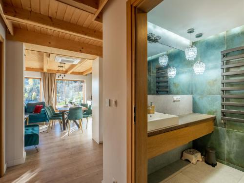 a bathroom with a sink and a dining room at Osada Gubałówka na Polanie Pająkówka View Jacuzzi & Sauna in Kościelisko