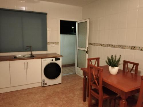 a kitchen with a table and a washing machine at La estrella del desierto in Tabernas