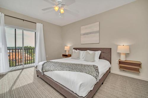 a bedroom with a bed and a large window at 2BR Condo with pool, near Disney! in Orlando