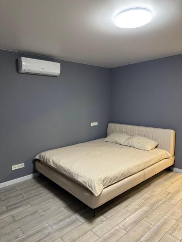 a bedroom with a bed in a blue wall at Простора і сучасна євродвушка в центрі Черкас! in Cherkasy