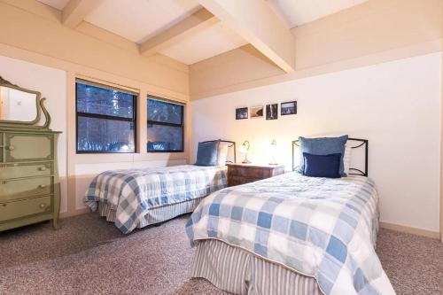 een slaapkamer met 2 bedden, een dressoir en 2 ramen bij Family-Friendly Lakefront Escape with Pool in Dollar Point