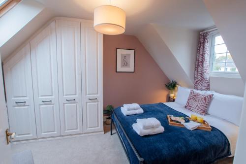 a bedroom with a blue bed with towels on it at Hazel House - Cosy 2 bedroom house with parking near to Oxford in Oxford