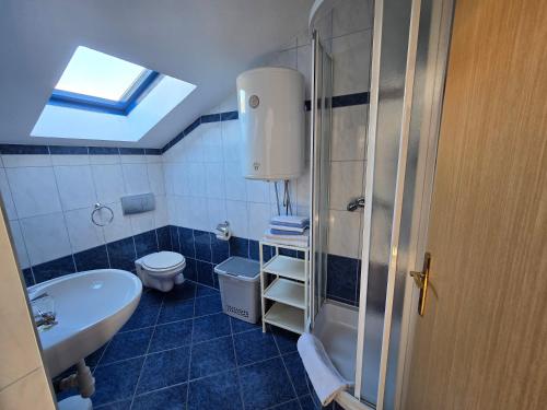 a bathroom with a sink toilet and a skylight at Apartmani Vanessa in Dramalj