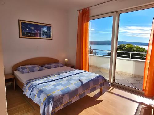 a bedroom with a bed and a large window at Apartmani Vanessa in Dramalj