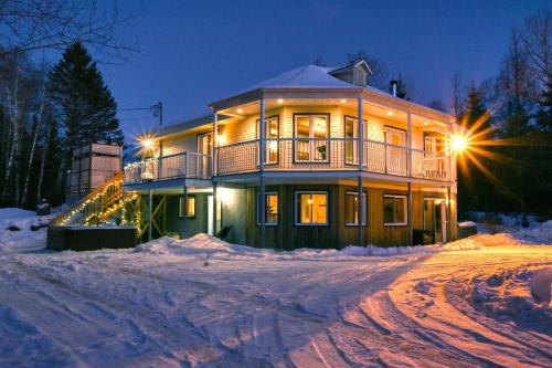 a large house in the snow at night at Spacious cottage in forest with spa in La Macaza