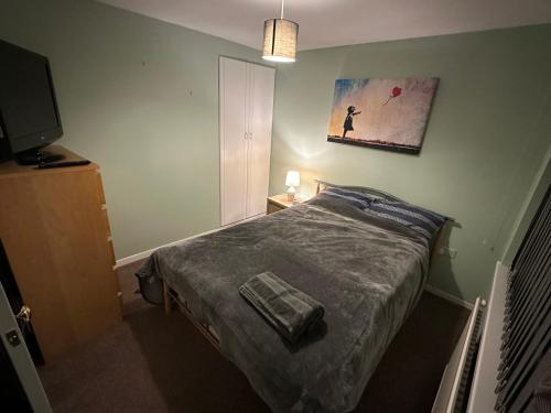 Un dormitorio con una cama y un cuadro en la pared. en Newport by M4, en Newport