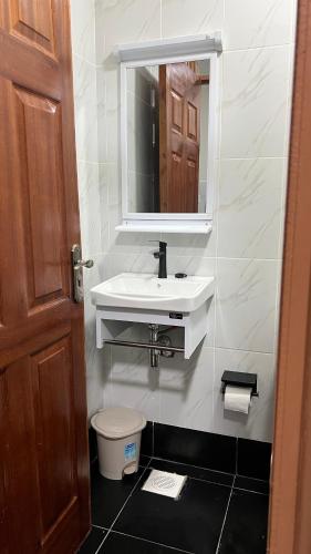 a bathroom with a sink and a toilet and a mirror at Amber Home Ruaka Near Two Rivers Mall & UN in Ruaka