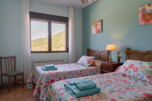 een slaapkamer met twee bedden en een raam bij Casas Rurales La Loma in Riópar