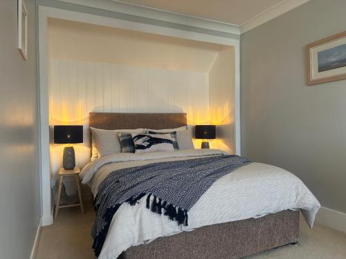 a bedroom with a large bed with two lamps at The Place in Johnshaven