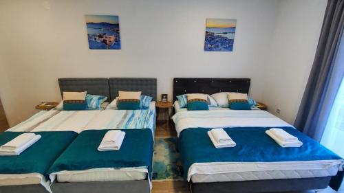 two beds in a room with blue and white at Apartmani Toki Balkana in Mrkonjić Grad