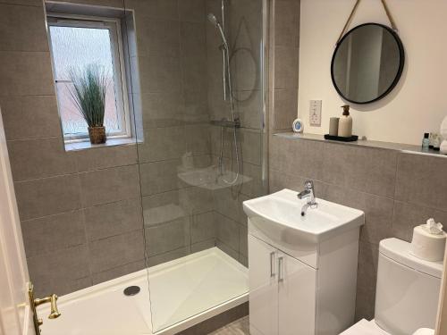 a bathroom with a sink and a toilet and a shower at Kinfirth Apartment in Ayr