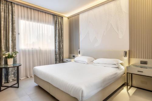 a bedroom with a large white bed and a window at Abacus Hotel in Sesto San Giovanni