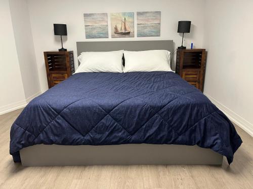 Un dormitorio con una cama con un edredón azul. en Merritt Place Niagara, en St. Catharines
