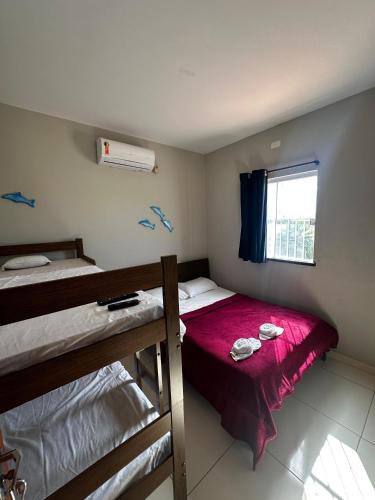 a bedroom with two bunk beds and a window at Joia do Paraiso - Macapá Luís Correia in Luis Correia