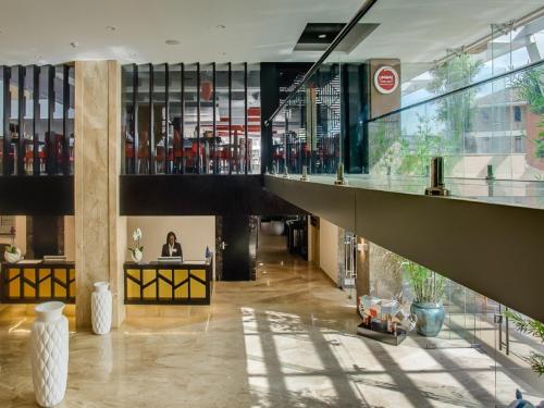 a lobby with a woman sitting at a desk in a building at The Concord Hotel & Suites in Nairobi