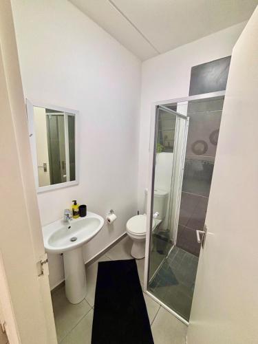 a bathroom with a toilet and a sink and a shower at Waterfall Smart Apartment 2bed2bath in Midrand