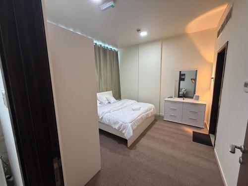 ein kleines Schlafzimmer mit einem Bett und einem Spiegel in der Unterkunft Suite one bedroom in Abu Dhabi