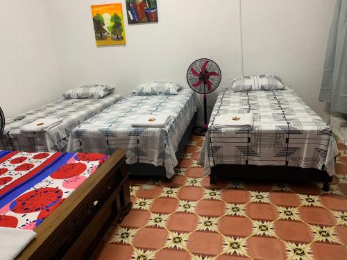 a room with two beds and a tiled floor at Hostal Y Hospedaje Familiar Amanecer del Valle 1 in Valledupar