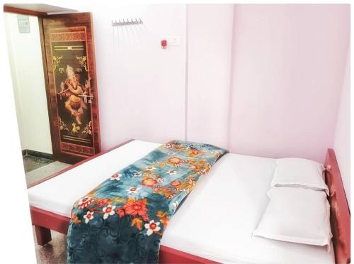 una piccola stanza con un letto con una coperta floreale sopra di Sri Hotel Ganga Couple&Family Friendly a Patna