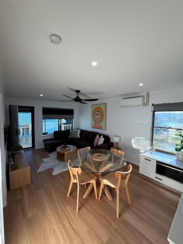 a living room with a table and a couch at Waters Edge - Dunbar Court - Central Location in South West Rocks